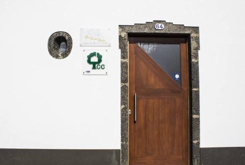 a door in a wall with a sign on it at Casa Lagar de Pedra T3 in Santa Cruz da Graciosa