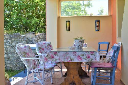 una mesa de comedor con sillas y una mesa con un jarrón. en Villa Niki, en Págoi