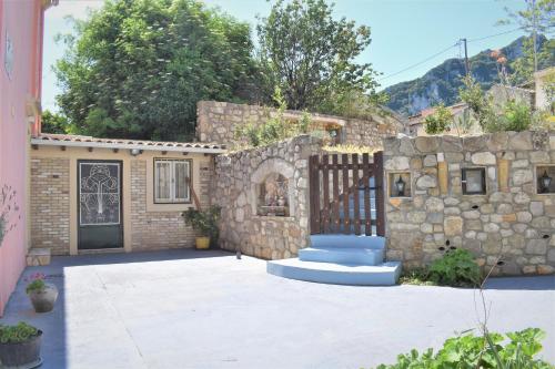 Casa de piedra con puerta y pared de piedra en Villa Niki en Págoi