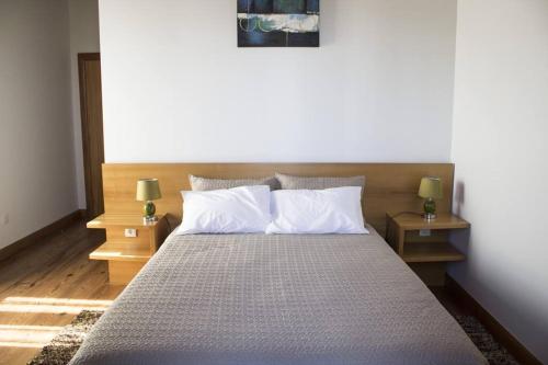 a bedroom with a large bed with two night stands at Casa Lagar de Pedra T3 in Santa Cruz da Graciosa