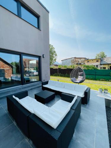 a patio with black and white furniture and a building at Apartmány 400 in Veľká Lomnica