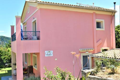 a pink house with a balcony at Villa Niki in Págoi