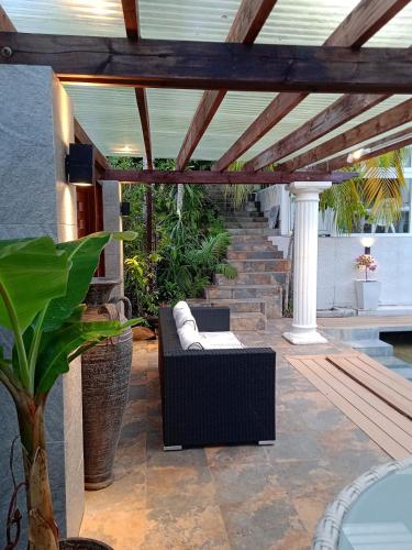 a patio with a couch sitting on a porch at Bois Joli in Mahe