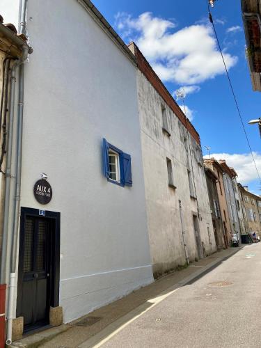 a white building with a blue window on a street at AUX 4 LOGIS Appart-hotel - Studio Le Flore - Petit déjeuner inclus 1ère nuit in Foix