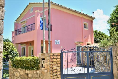 a pink house with a gate in front of it at Villa Niki in Págoi