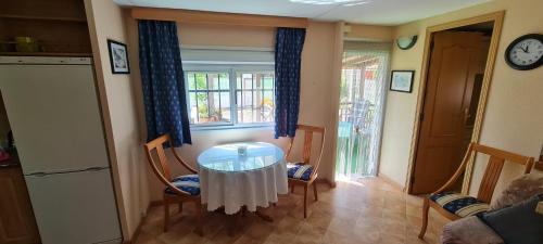 Habitación con mesa, sillas y ventana en Casa Fernandet 3 bedrooms house, en Sueca