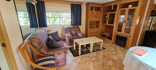 sala de estar con 2 sillas y mesa en Casa Fernandet 3 bedrooms house en Sueca