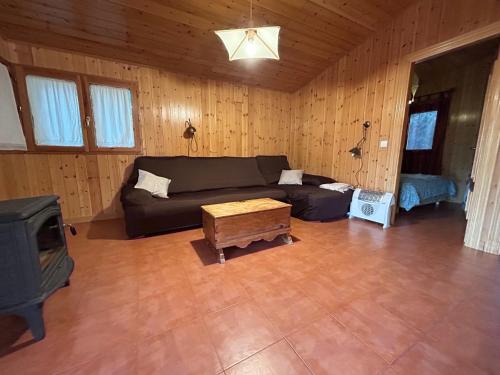 een woonkamer met een bank en een tv bij Mi casita de madera in Segovia