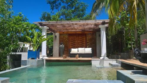 a villa with a swimming pool and a pavilion at Bois Joli in Mahe