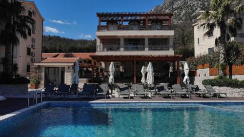 un hotel con una piscina con sillas y un edificio en Bellezza Resort & SPA en Kotor