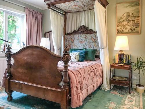 1 dormitorio con cama con dosel en una habitación en An Tabhall, en Glencripesdale