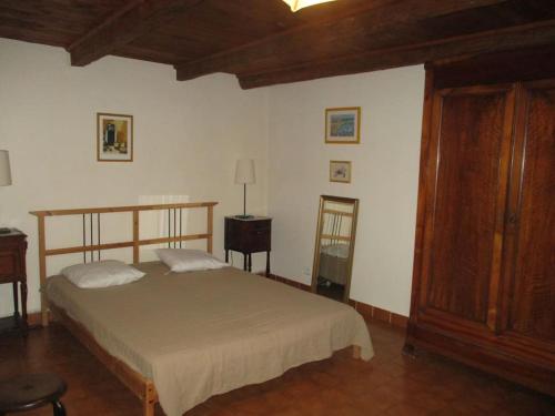 une chambre avec un lit et une armoire en bois dans l'établissement Gite LaMothe en Aveyron, à Salles-Courbatiès
