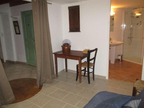 une petite table et une chaise dans une chambre avec salle de bain dans l'établissement Gite LaMothe en Aveyron, à Salles-Courbatiès