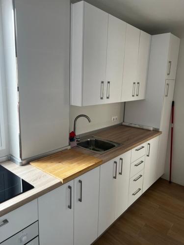 uma cozinha com armários brancos e um lavatório em Apartamento Arenas em Nerja