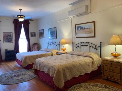 een slaapkamer met 2 bedden en een raam bij Historic Capitol Hotel Vacation Suites Downtown in Buffalo