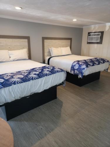 two beds in a hotel room with two beds sidx sidx sidx at Tides Motel - Hampton Beach in Hampton