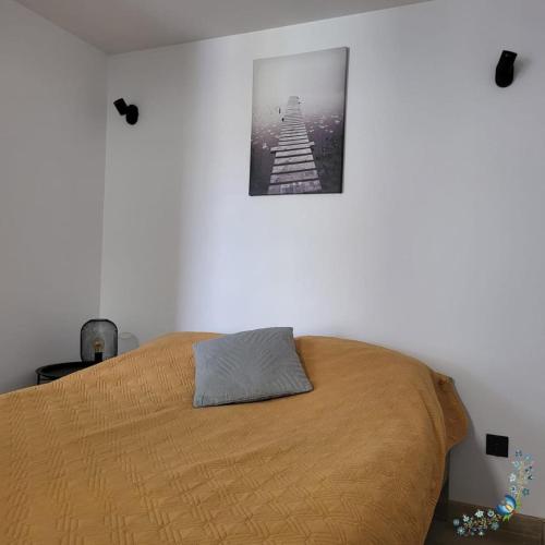 Studio 4-osobowe في Gowidlino: غرفة نوم بسرير مع صورة على الحائط