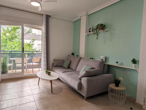 - un salon avec un canapé et une table dans l'établissement Apartamento Las Palmeras - Con Terraza, barbacoa, aire acondicionado y a 250m de la playa!, à Los Alcázares