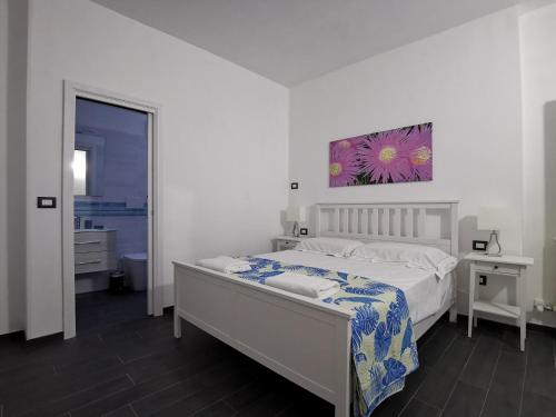 1 dormitorio con 1 cama y una pintura en la pared en B&B The Sun 'tis, en Castro di Lecce