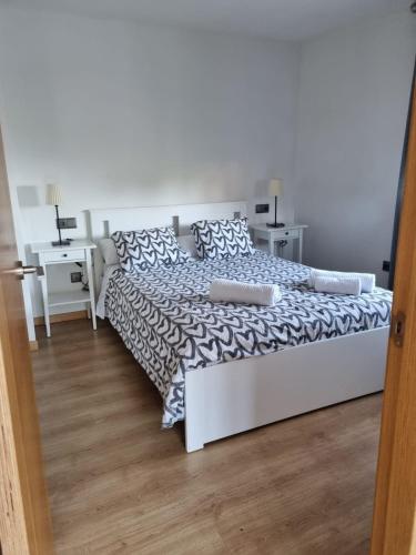a white bed in a bedroom with a table at Casa As Neves - 1B Gran Ventanal in Malpica