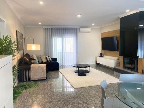 a living room with a couch and a tv at Casa da Luna in Matosinhos