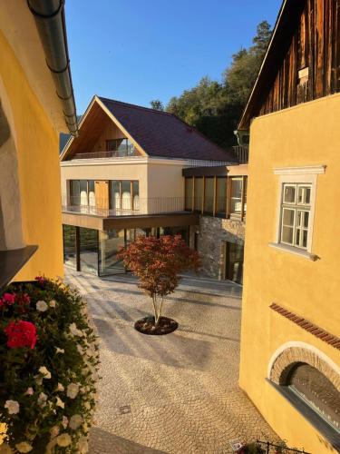 a house with a tree in the middle of a courtyard at Weingut FJ Gritsch Mauritiushof Apartments in Spitz
