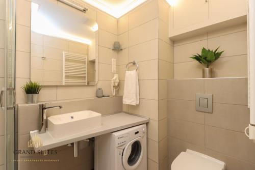 un bagno con lavandino e lavatrice di Grand Suites Central a Budapest