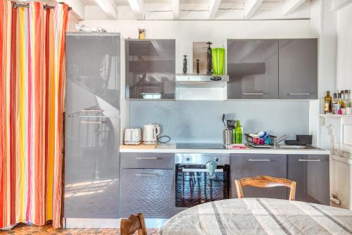 a kitchen with stainless steel appliances and a table at Gîte Monkey cottage in Bouchemaine