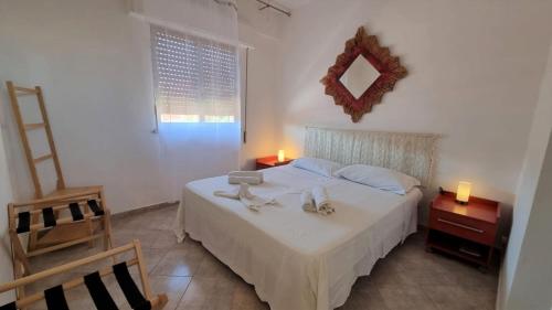 sypialnia z białym łóżkiem i lustrem w obiekcie BILO EGADI E MONO EGADI w mieście Favignana