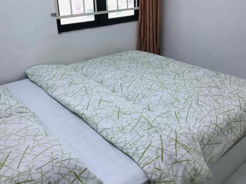 Bett in einem Zimmer mit einem Bettlaken mit Gras in der Unterkunft 365 House by D'Laksamana in Malakka