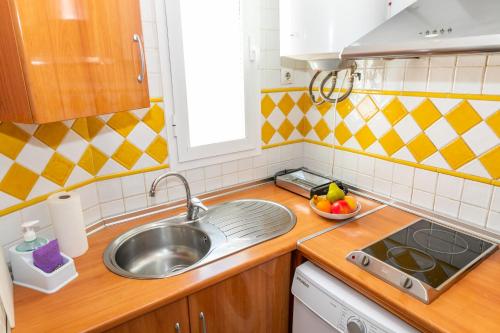a kitchen with a sink and a bowl of fruit on the counter at apartamento playa chica in Barbate