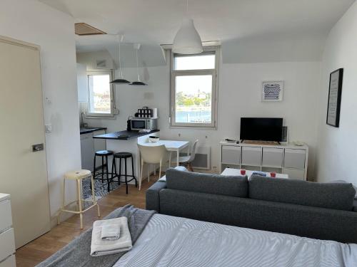 un salon avec un canapé et une cuisine dans l'établissement Appartement Design VI Port de Tréboul Douarnenez, à Douarnenez