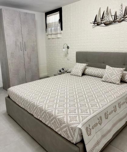 a bedroom with a large bed with a white comforter at APPARTAMENTO PICASSO in Villasimius