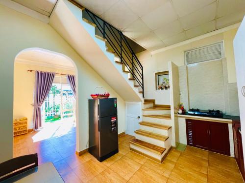 a living room with a staircase and a refrigerator at MiUon House R in Ấp Ða Lợi