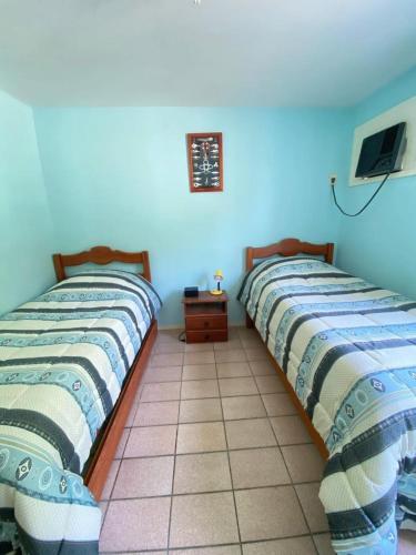 two beds sitting next to each other in a room at Beautiful 3 Bedrooms with Barbecue Deck Angra Pool in Angra dos Reis