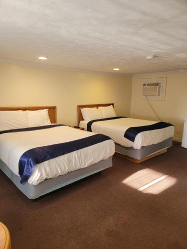 two beds in a hotel room with two bedsvisor at Tides Motel - Hampton Beach in Hampton