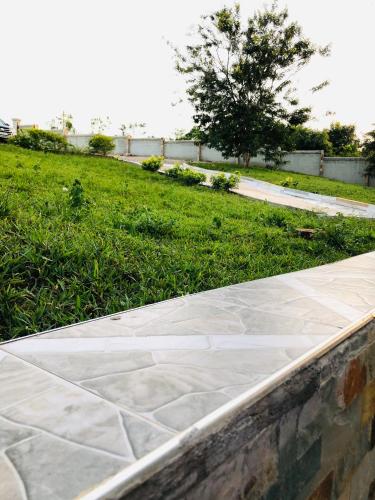 a stone walkway next to a field of grass at Mavern House Apartments in Elmina