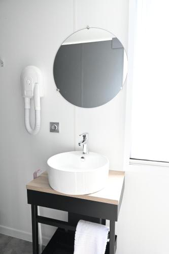 uma casa de banho com um lavatório branco e um espelho. em Agricampeggio Ippocampo em La Cinquantina