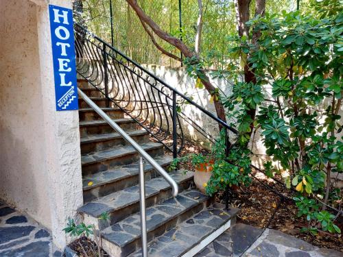 un escalier avec un panneau sur le côté du bâtiment dans l'établissement Hôtel Cap Soleil, à Cavalaire-sur-Mer