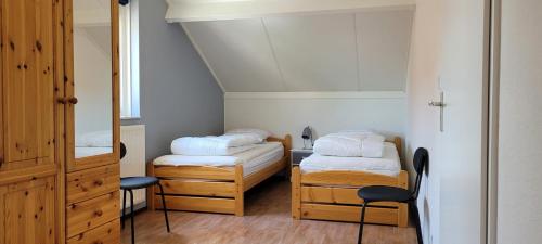 een kleine kamer met 2 bedden en een spiegel bij Kustverhuur, Park Scheldeveste, Schelde 58 in Breskens