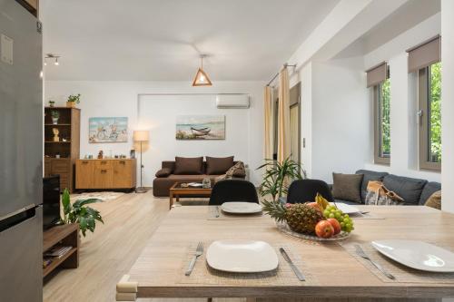 una sala de estar con una mesa con fruta. en ModernPastel Apartment - Near Old Port with parking en La Canea