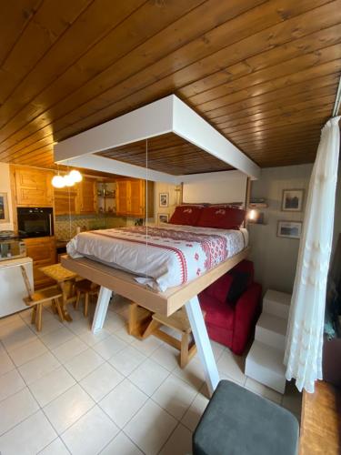 1 dormitorio con 1 cama grande y techo de madera en Ladybird Inn, en Chamonix-Mont-Blanc