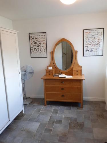 a bathroom with a wooden dresser and a mirror at Åberg12 in Höör