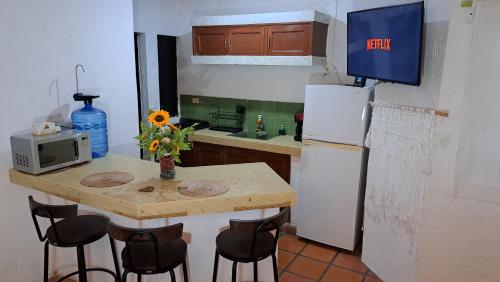cocina con mesa pequeña y nevera en Apartamento Bizantino en Cozumel