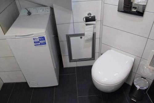 a bathroom with a white toilet and a mirror at Small Cozy Apartment in Gloppen in Vereide