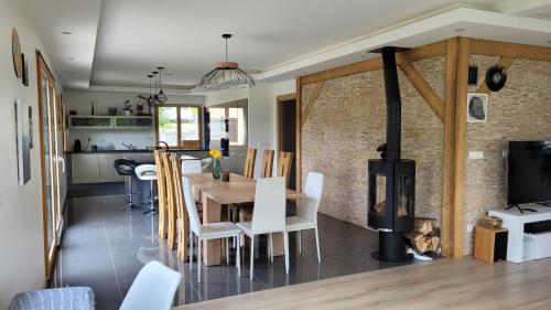 a kitchen and dining room with a wood stove at Chez Lily et Bruno in Morbier