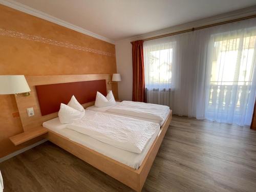 una camera da letto con un grande letto con lenzuola bianche di zum Schwanen Garni a Buggingen