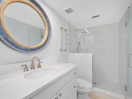 a bathroom with a sink and a toilet and a mirror at El Mar Villa in Ponte Vedra Beach