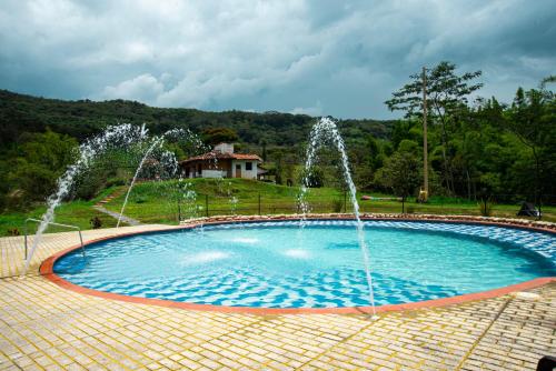 a pool with two water fountains in a park at Glamping brisa de guadua in Moniquirá