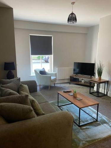 a living room with a couch and a tv at Poplar House-2Bedroom house in town centre with free Parking by ShortStays4U in King's Lynn